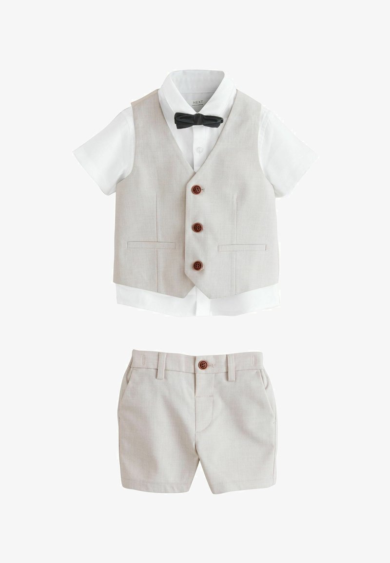 Chemise blanche à manches courtes avec nœud papillon noir, gilet beige boutonné et short beige assorti pour un tout-petit.