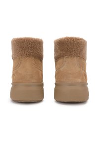 Botas de ante color tostado con un acogedor cuello de borreguito beige, altura hasta la pantorrilla, punta redondeada y suela de goma gruesa y texturizada.