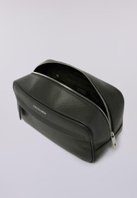 Černá toaletní taška z texturované kůže se stříbrným zipem, přední kapsou a značkou "TRUSSARDI" na světlém pozadí.