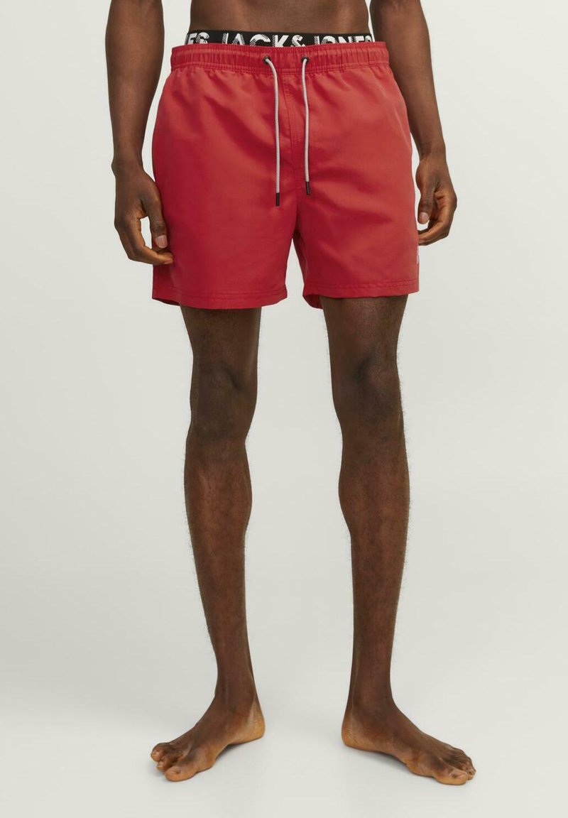 Rode zwemshorts met een trekkoord in de taille en een contrasterende grijze koord. Glad materiaal, knielange snit, minimale stikdetails.