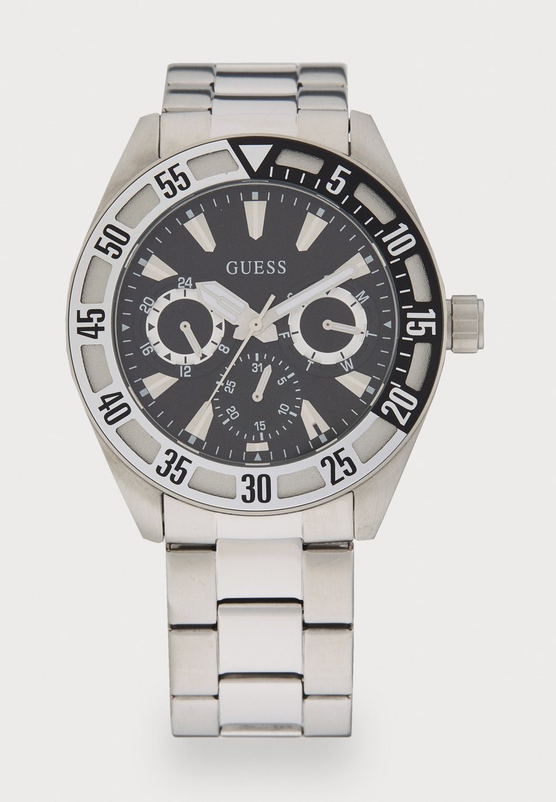 Silver stainless steel watch with a black dial, large numeral markers, chronograph subdials, and a textured bezel displaying minute indicators.