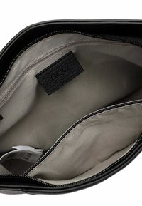 Innenansicht einer schwarzen Lederhandtasche mit einer glatten, hellgrauen Fütterung. Verfügt über eine Reißverschlusstasche und ein strukturiertes Etikett, das innen eingenäht ist.