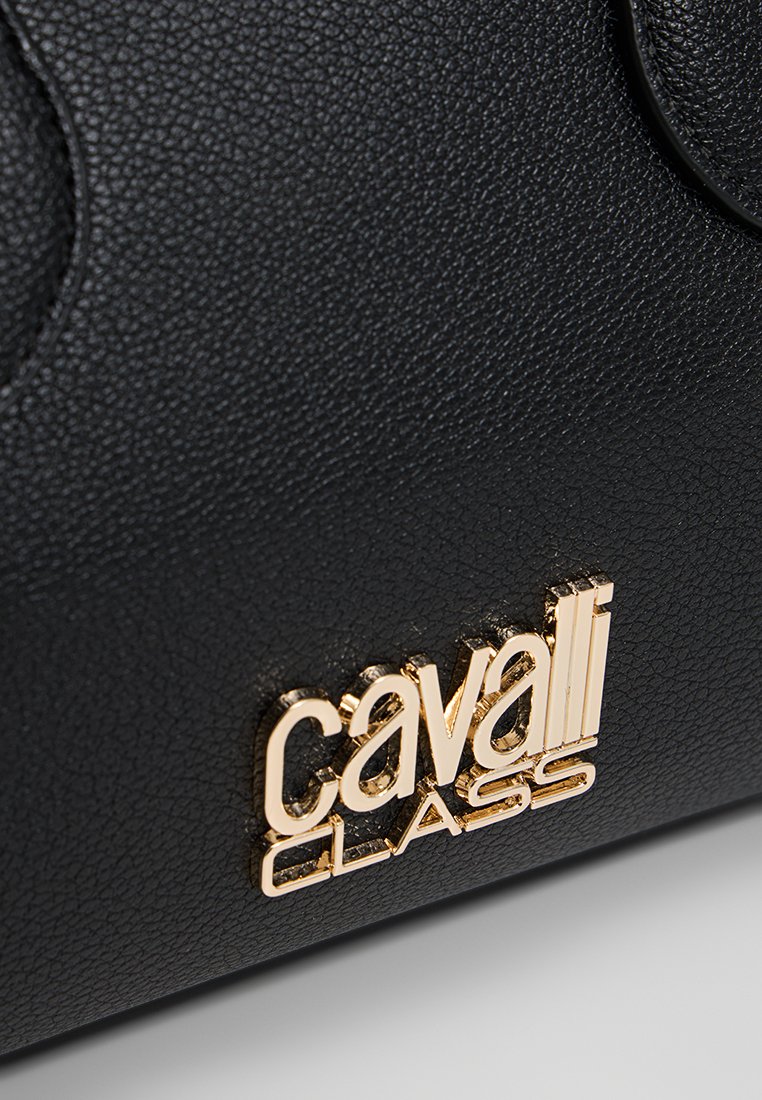 Bolso de mano de cuero texturizado negro con un prominente logo en tono dorado "cavalli CLASS" en el frente. Los acentos incluyen un acabado suave y bordes redondeados.