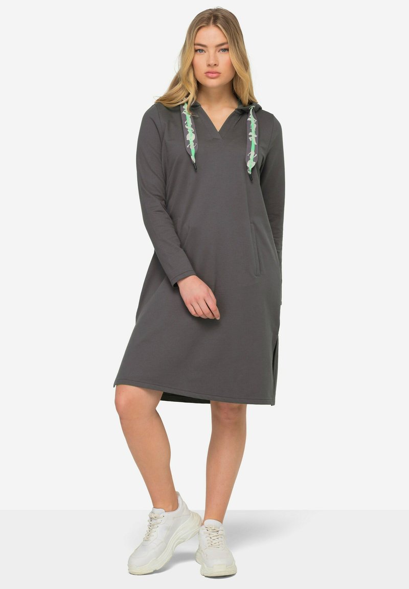 Robe à capuche grise avec des manches longues, dotée d'une poche avant et de cordons de serrage à motif vert. Tissu doux avec une coupe décontractée.