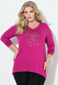Tunic fucsia a maniche lunghe con scollo a V, decorato con un design di rose in strass e la parola "LOVE" sottostante, abbinato a leggings neri.