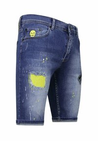 Denim shorts, donkerblauw met een versleten afwerking, met rafelige patches en neongele accenten, inclusief een doodskop detail op de zak.