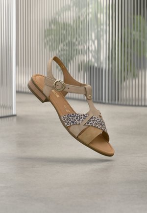 Μπεζ σανδάλι με λεπτομέρειες λεοπάρ, στρογγυλό αγκράφα, ανοιχτό δάχτυλο και χαμηλό ξύλινο τακούνι· κατασκευασμένο από σουέντ και δέρμα.