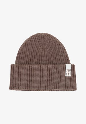 Bruine geribbelde gebreide muts met een opgevouwen boord en een wit label met het woord "seaSIDE" en golvende lijnen, gemaakt van zacht materiaal.