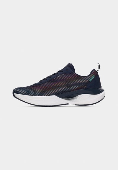 Chaussure de sport bleu marine avec tige en mesh ornée de points multicolores, semelle blanche amortissante, lacets et languette au talon sur fond neutre.