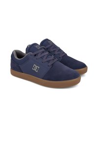 Navy blue sneakers made of suede and synthetic materials, featuring a rubber sole, lace-up design, and grey accents. Logo on the side.