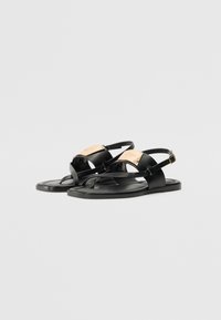 Sandale negre plate cu bretele ajustabile, din material de cauciuc, design minimalist, având un accent auriu în partea superioară.