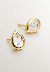 Pendientes en forma de lágrima de oro con cristales facetados claros rodeados de un acabado dorado suave. Con cierres para fácil uso y sujeción segura.