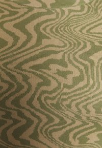 Têxtil listrado com um padrão ondulado em verde e bege, feito de material tricô macio com uma textura suave.