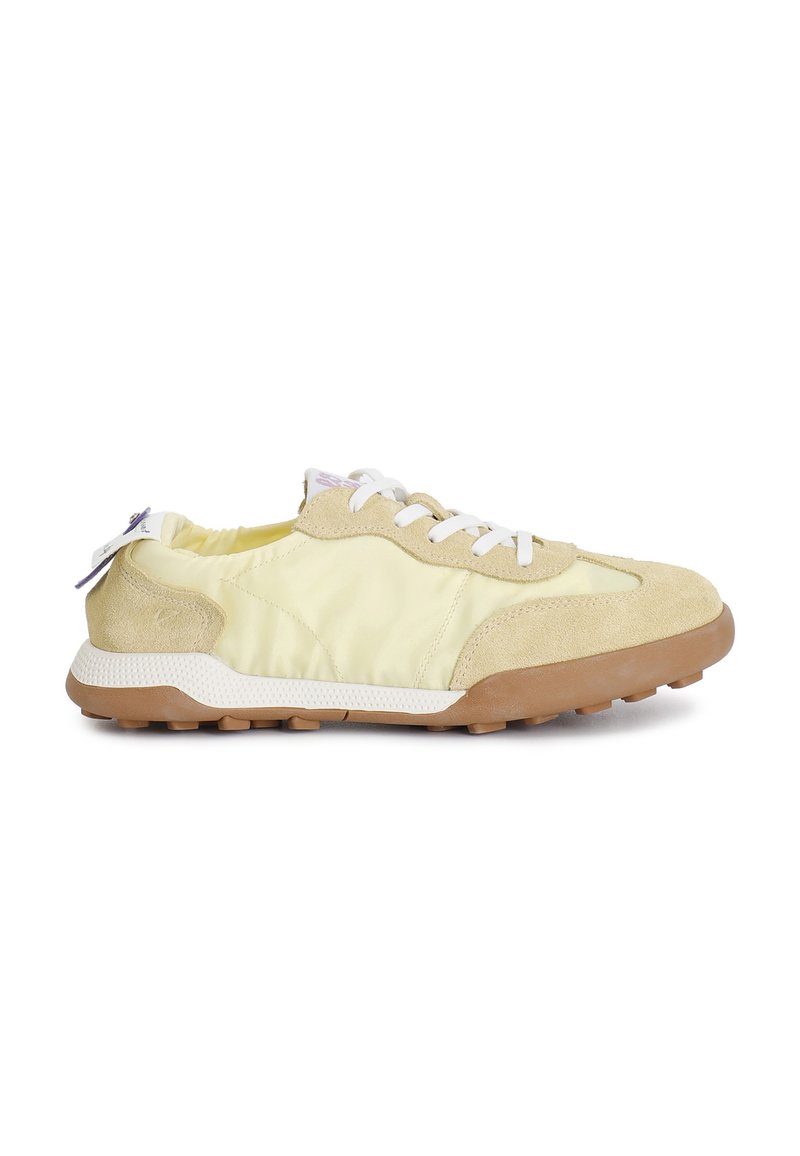 Sneaker giallo chiaro realizzate in suede e tessuto, con lacci bianchi, suola in gomma testurizzata e suola esterna beige a contrasto.