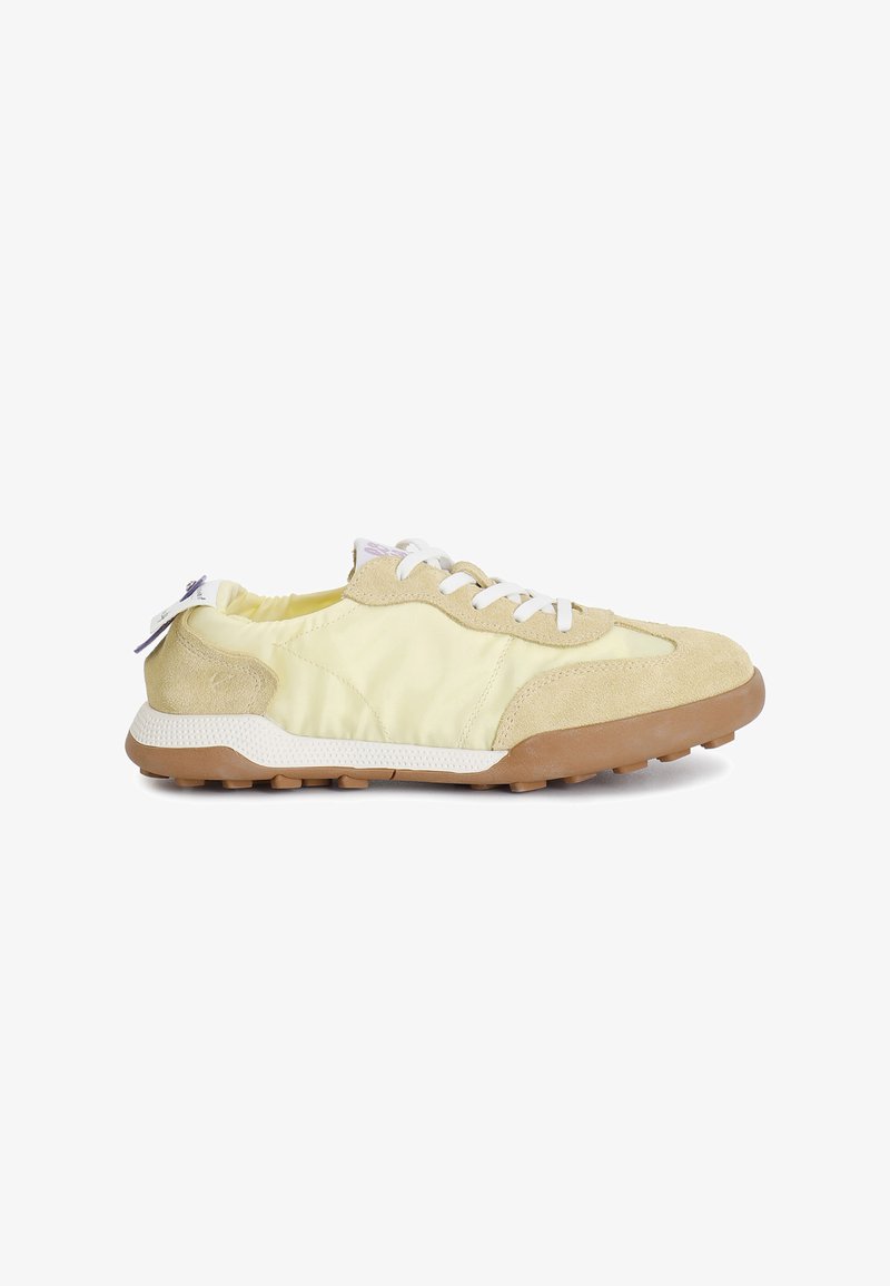 Sneaker giallo chiaro realizzate in suede e tessuto, con lacci bianchi, suola in gomma testurizzata e suola esterna beige a contrasto.