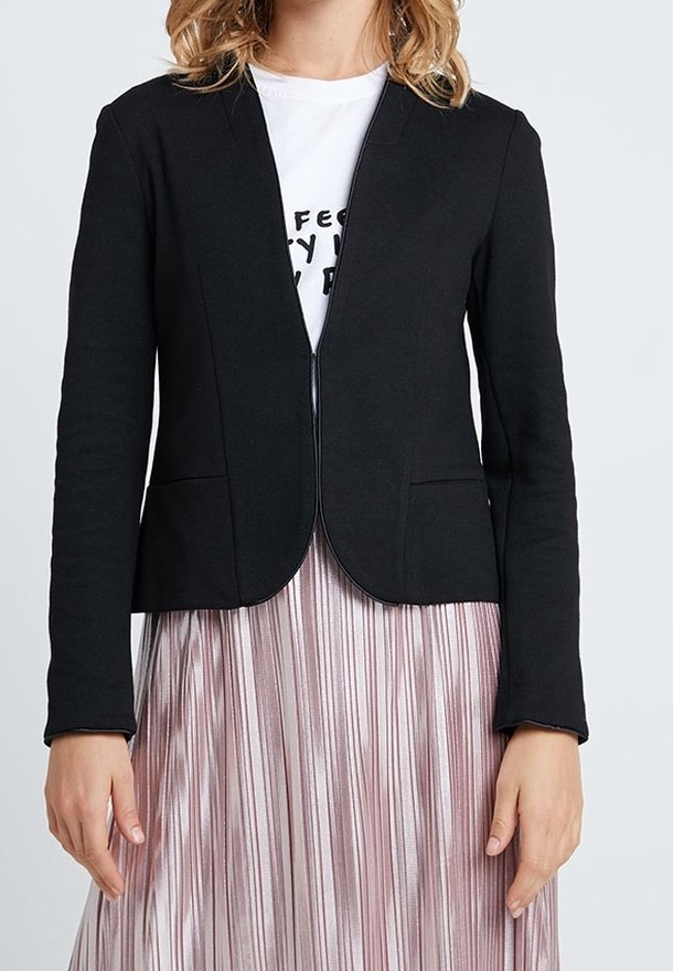 Czarna marynarka o dopasowanym kroju, z otwartym przodem i dwoma przednimi kieszeniami, zestawiona z plisowaną różową spódnicą. Materiał wydaje się gładki i lekko elastyczny.