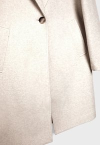 Beige uldblandingsfrakke med spids krave, enkelt knaplukning og to sidelommer med en glat, struktureret overflade.