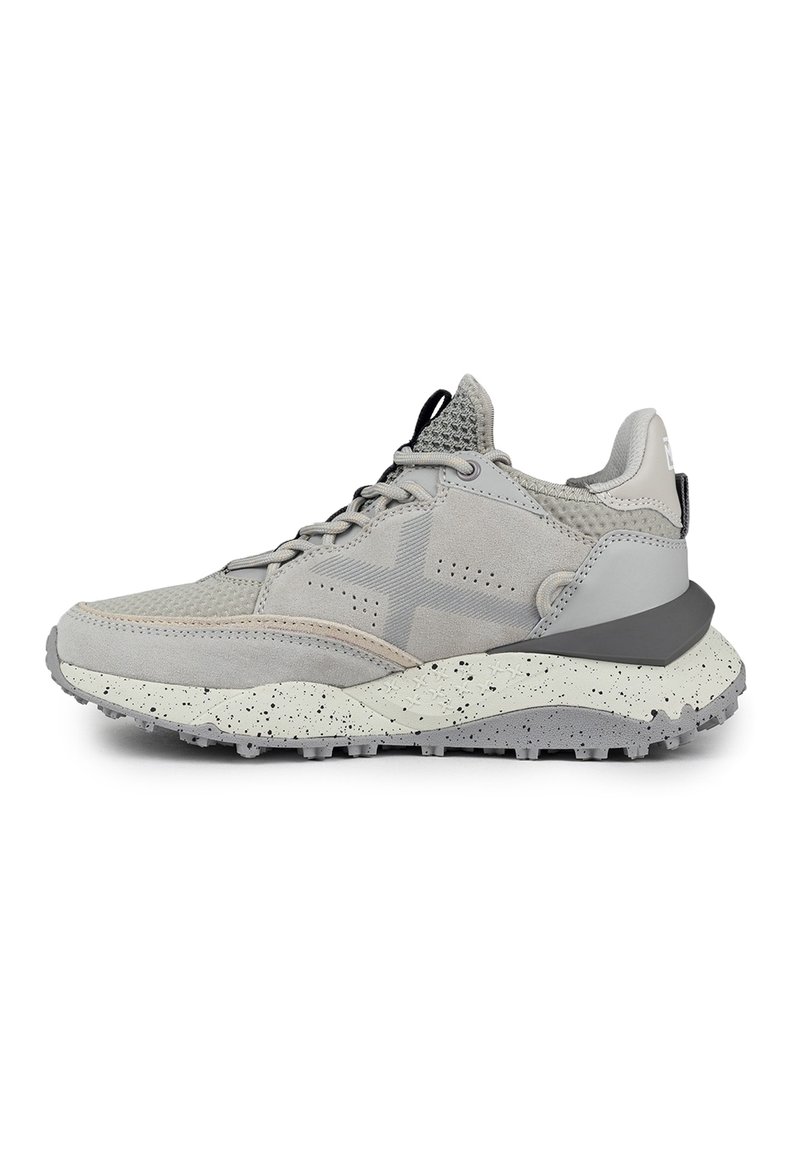 Scarpa sportiva grigia con un mix di materiali in suede e mesh, tomaia texturizzata, suola intermedia bianca a pois in contrasto e suola esterna in gomma flessibile.