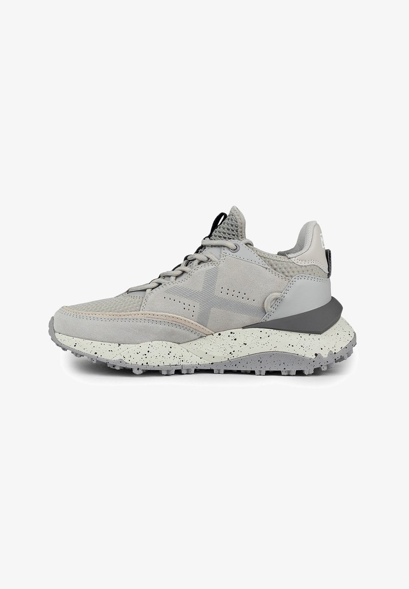 Zapatilla deportiva en gris con una mezcla de materiales de ante y malla, parte superior texturizada, mediasuela moteada blanca en contraste y suela de goma flexible.