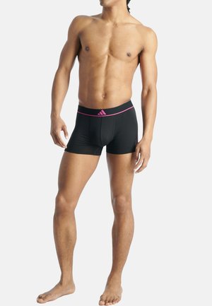 Caleçons de sport noirs en tissu lisse avec une ceinture rose arborant le logo Adidas, mettant en avant un ajustement confortable.