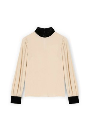 Jasnokremowa bluzka z długimi rękawami, bufiaste ramiona, czarny aksamitny kołnierzyk i czarne prążkowane mankiety. Gładka tekstura o prostym wzornictwie.