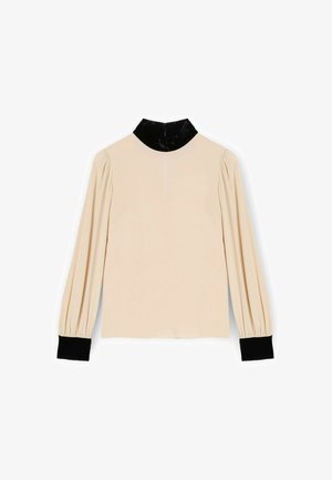 Jasnokremowa bluzka z długimi rękawami, bufiaste ramiona, czarny aksamitny kołnierzyk i czarne prążkowane mankiety. Gładka tekstura o prostym wzornictwie.