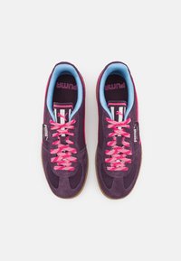 Pantofi sport mov cu superior din plasă și suede, șireturi roz, guler albastru și talpă din cauciuc de tip gumă. Prezintă detalii cu logo pe lateral.