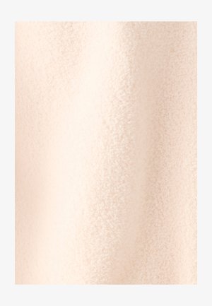 Tela esponjosa suave de color beige claro con una textura acolchada, que muestra una superficie lisa y ligeramente brillante sin patrones visibles ni elementos metálicos.