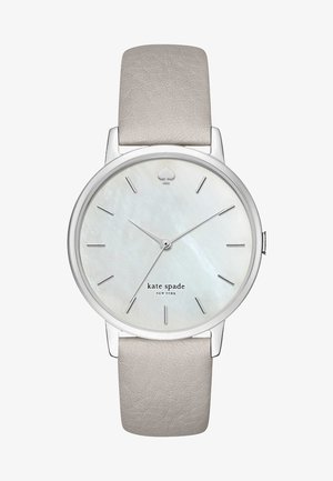 Srebrny zegarek na nadgarstek z okrągłą kopertą, tarczą z masy perłowej, minimalistycznymi znacznikami godzin i miękkim szarym skórzanym paskiem. Zawiera logo w kształcie łopaty.