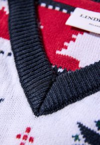 Rood en wit patroon gebreide trui met een donkergrijze geribde V-halskraag. De stof heeft een zachte textuur. Etiket zichtbaar.