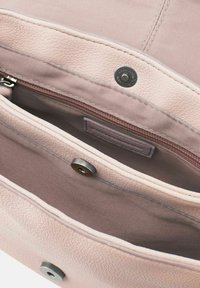 Interno di una borsa texturizzata rosa con tasca con zip, chiusura a pulsante metallico e rivestimento in tessuto liscio. Presenta più scomparti per l'organizzazione.