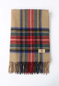 Coperta di plaid in lana con una base beige e strisce rosse, verdi e blu, e bordi frangiati. L'etichetta nell'angolo recita "BELLE MERE."