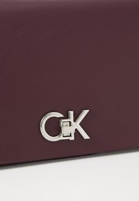 Calvin Klein CONVERTIBLE MINI BAG - Cross body bag - vineyard wine