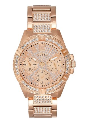 Zegarek Guess w różowym złocie z pierścieniem, tarczą i ogniwami bransolety zdobionymi kryształami, posiadający trzy subtarcze wskazujące 24-godzinny czas, datę i dzień tygodnia.