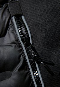 Chiusura con zip nera e fodera in tessuto texturizzato. Presenta un cursore e un binario della zip lucidi, completati da una finitura morbida e opaca.