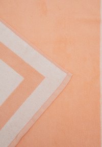 Asciugamano pesca con strisce zigzag bianche, superficie texturizzata e bordo rinforzato. Il tessuto morbido ne migliora l'assorbenza e il comfort.