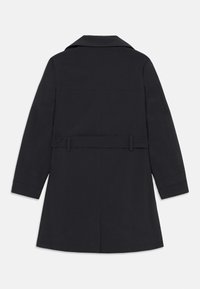 Manteau noir au design ajusté, avec un large col, des manches longues, une taille ceinturée et une fente au milieu du dos. Texture lisse, sans motifs visibles.
