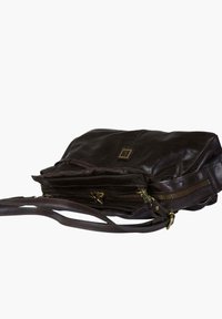 Borsa a tracolla in pelle marrone dalla texture liscia, dotata di una tasca con cerniera, tracolla regolabile e un piccolo logo decorativo sul davanti.