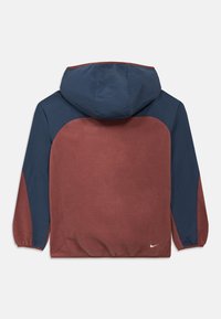 Giacca con cappuccio dal corpo color amaranto e maniche blu navy. Realizzata in tessuto strutturato. Presenta polsini elastici e un piccolo logo del marchio in basso.