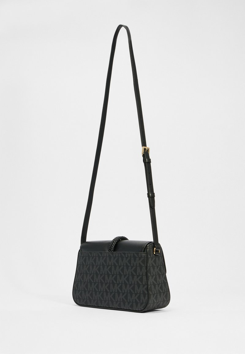 Schwarze Umhängetasche mit Lederakzenten und einem gemusterten Stoff, der die Buchstaben "MK" zeigt. Verstellbarer Riemen und geflochtenes Handdetails.