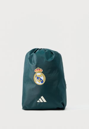 Sac à cordon vert foncé avec le logo du club de football du Real Madrid et le logo blanc Adidas sur un fond uni.
