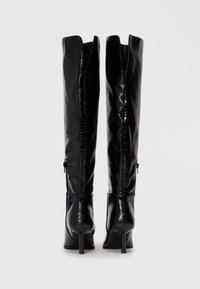 Schwarze knielange Stiefel aus glänzendem Krokodil-Präge-Material, mit schmalem Stiletto-Absatz und einem Reißverschluss im Rücken.