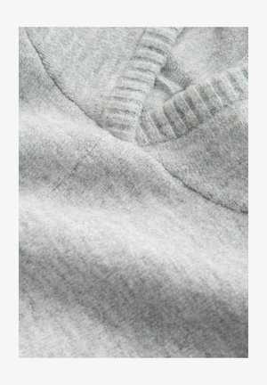 Tissu en tricot gris clair avec une finition texturée, doté d'un col en V côtelé et d'une surface douce et lisse.