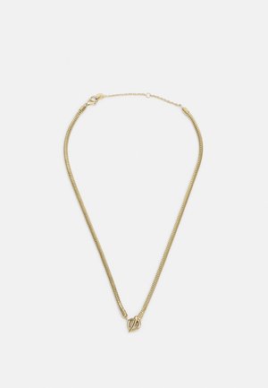 Collier chaîne ton or avec un fermoir à bascule en forme de cœur sur un fond uni clair.