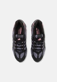 Black and gray sneakers with a mesh design, featuring pink accents and laces, rounded toe, and textured rubber sole.