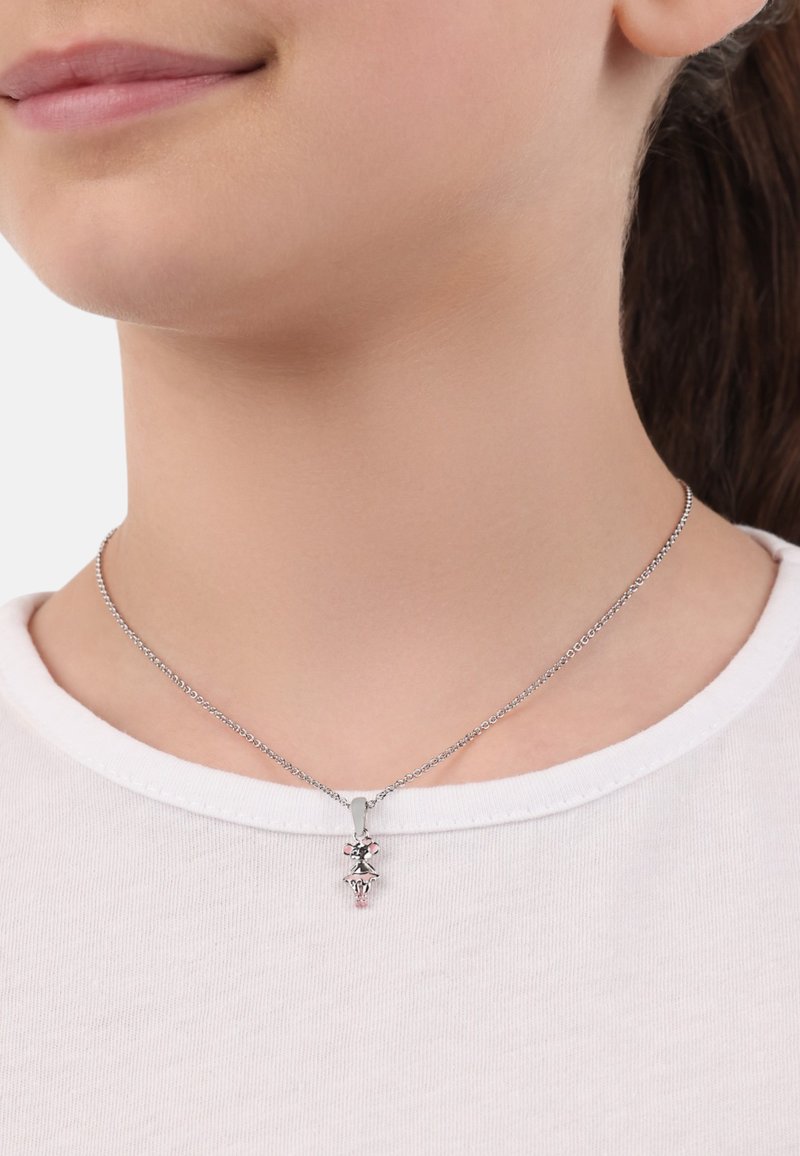 Collana d'argento con un delicato pendente caratterizzato da un design floreale, catena texturizzata, indossata sopra una camicia bianca.