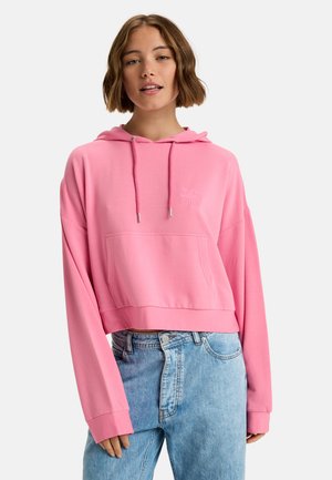 Hoodie cropped rose avec une poche avant, capuche à cordon de serrage et logo brodé. Le tissu semble doux et lisse, avec de longues manches.