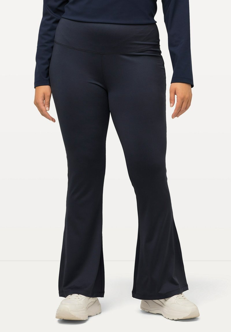 Pantaloni yoga blu navy con fondo svasato, realizzati in un tessuto liscio ed elasticizzato. Presentano un ampio e comodo elastico in vita per un supporto aggiuntivo.