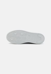 Fehér sneaker talp halszálka mintázattal, kerek tapadási pontokkal és texturált szegéllyel. Gumi alapanyagból készült, sima felülettel.