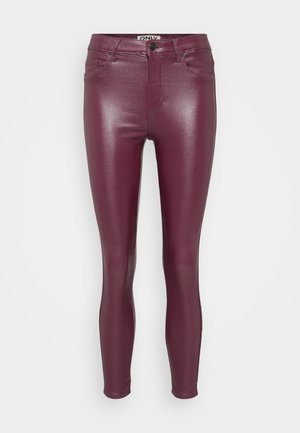 Jean skinny en simili cuir bordeaux avec une finition brillante, présentant une taille standard, des poches frontales et une coupe ajustée sur l'ensemble des jambes.